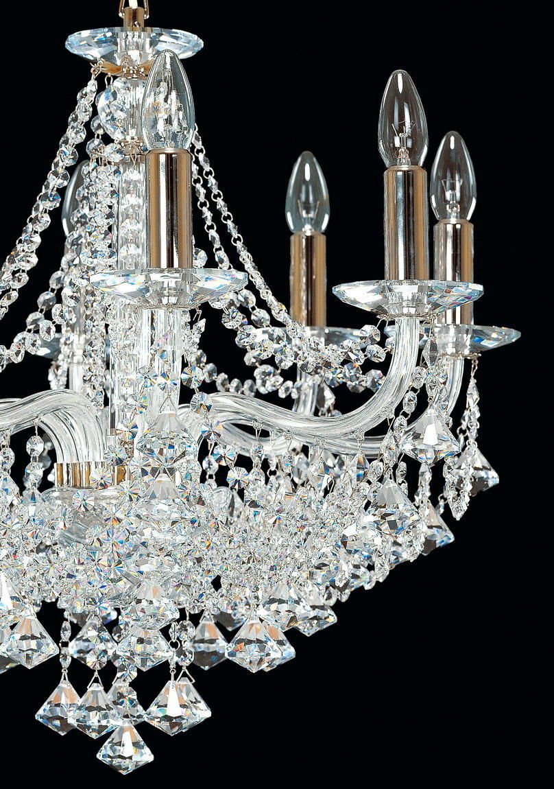 Détail rapproché des bras courbes, des coupelles et des pendeloques en cristal.
