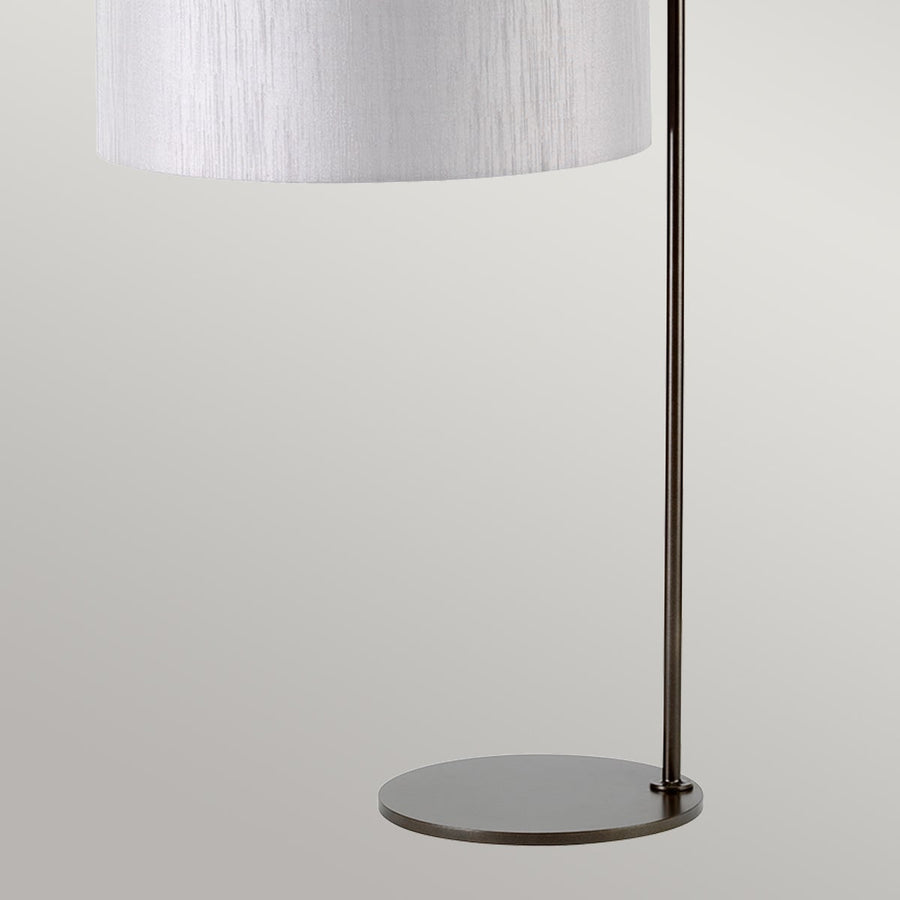 Gros plan du pied circulaire et du montant métallique fin de la lampe