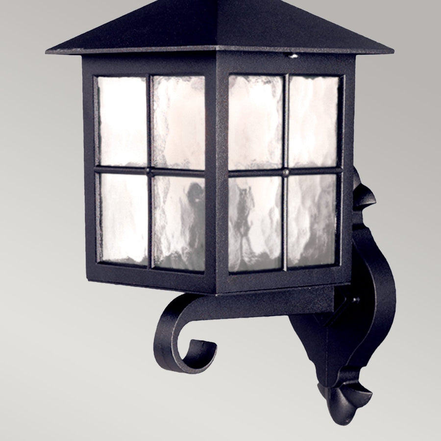 Vue rapprochée du luminaire noir montrant le verre texturé et les fixations.