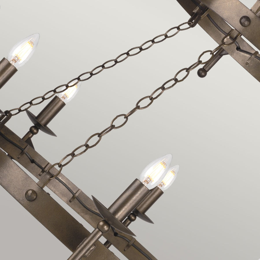 Vue en contre-plongée des chaînes de suspension et des bras métalliques du lustre.