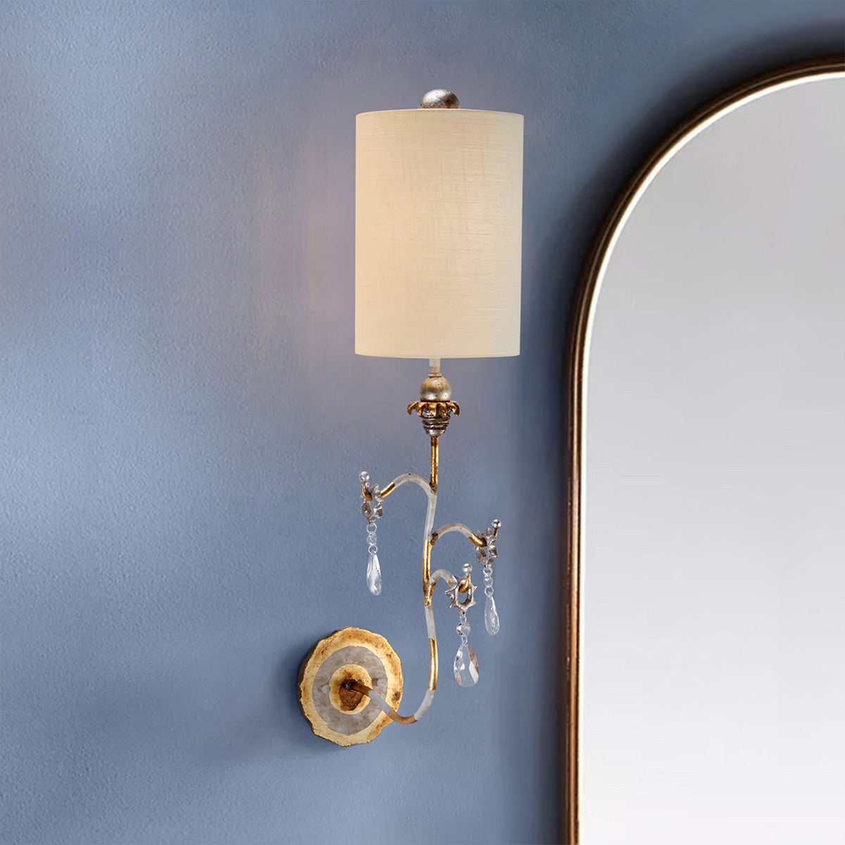 Mise en ambiance sur mur bleu, près d'un grand miroir à cadre doré