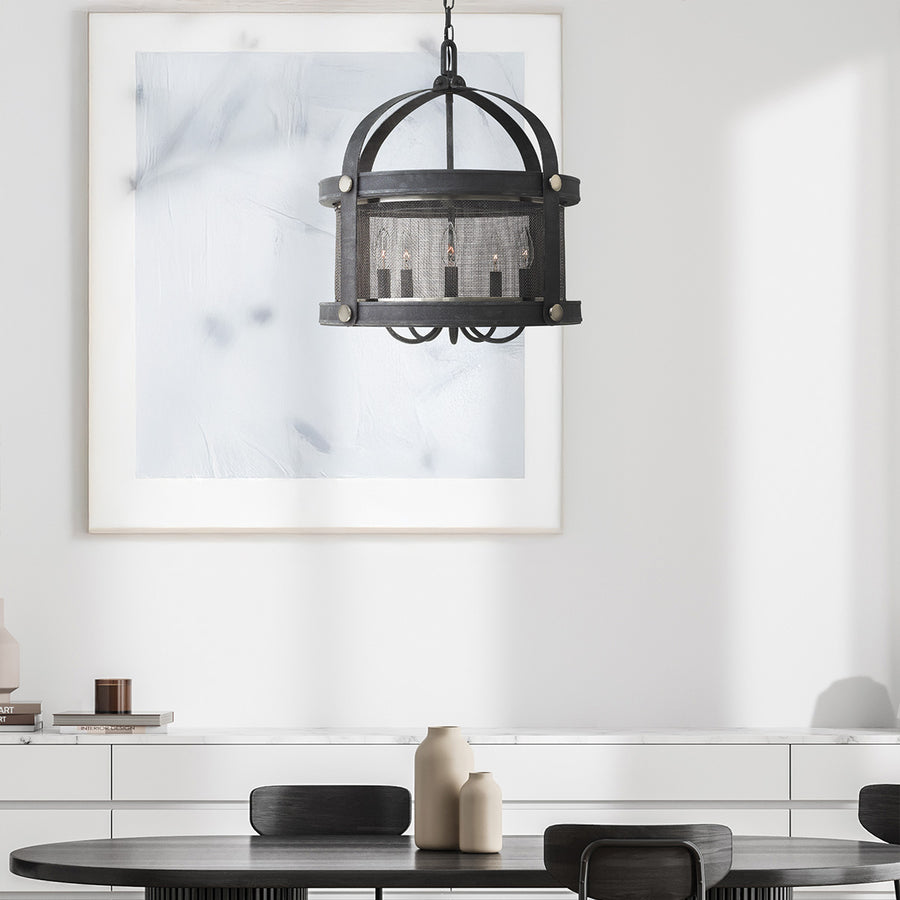 Lustre suspendu au-dessus d'une table à manger dans un intérieur blanc épuré