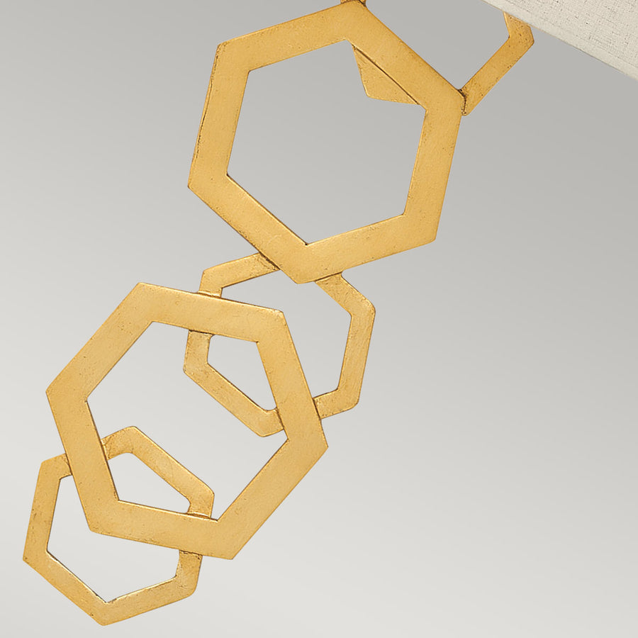 Gros plan sur les anneaux hexagonaux dorés formant la structure suspendue