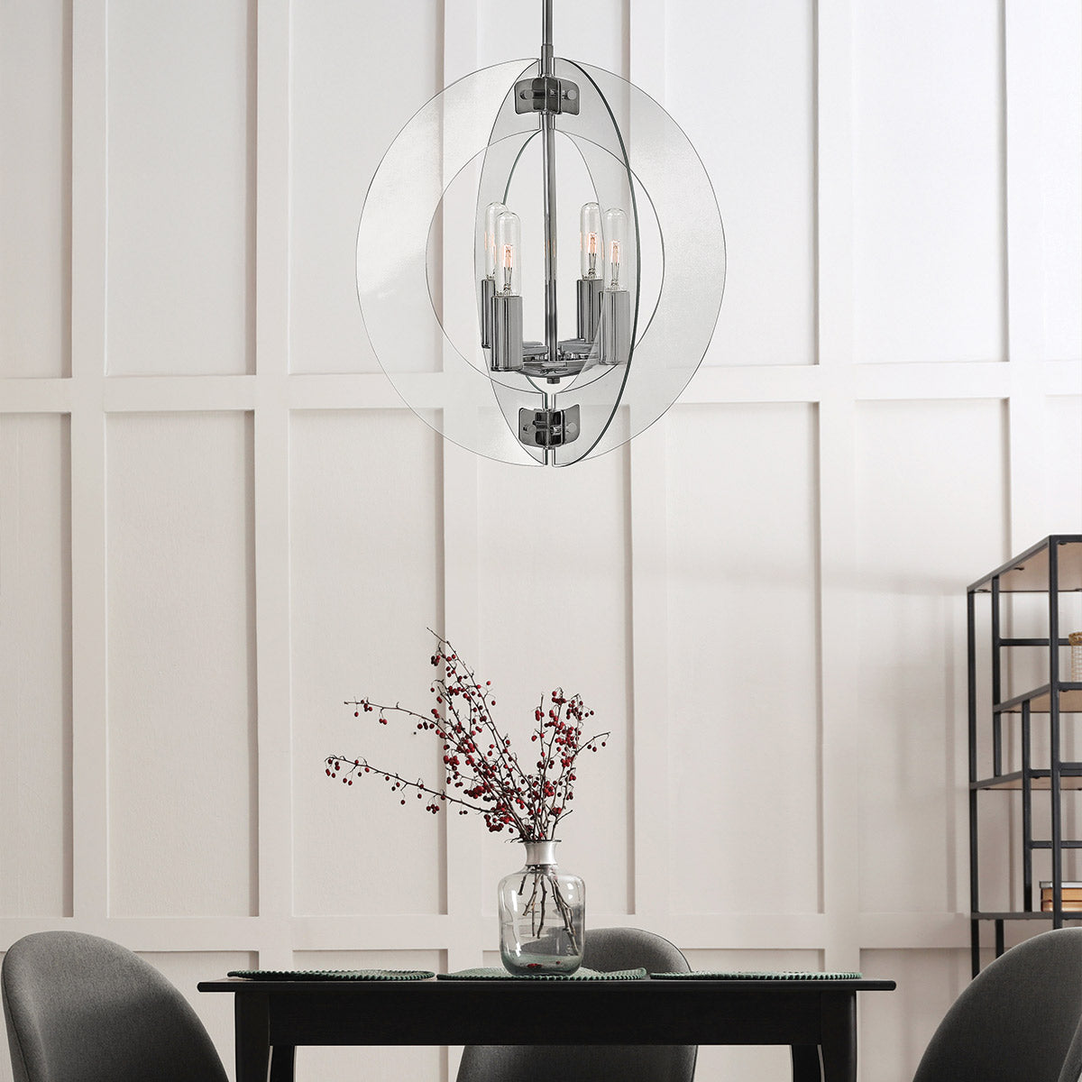 Lustre installé au-dessus d'une table, mur blanc à panneaux et vase de branches.