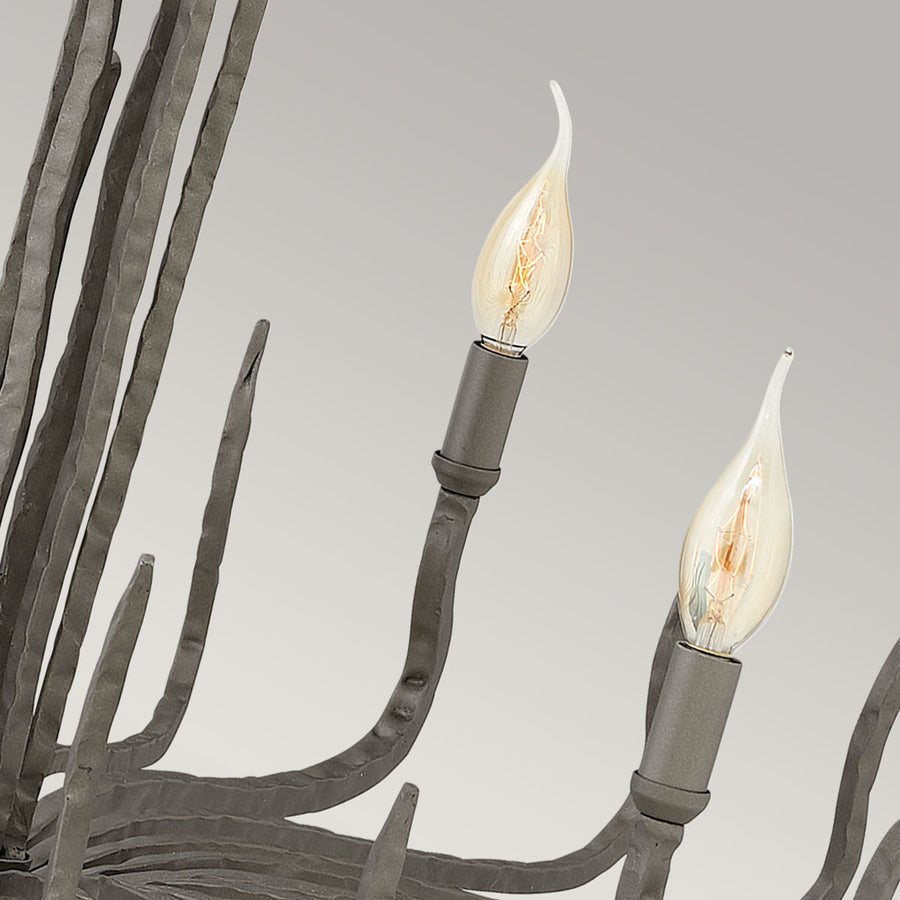 Détail des douilles et ampoules flammes sur les bras courbes du luminaire.