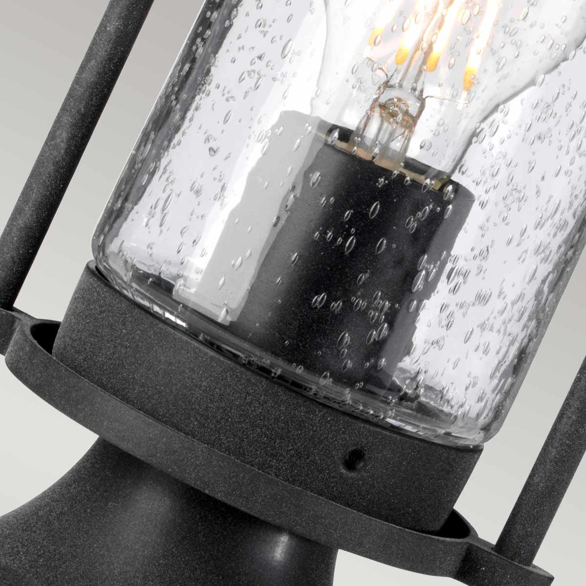 Gros plan du verre gouttelettes et de l'ampoule à filament allumée