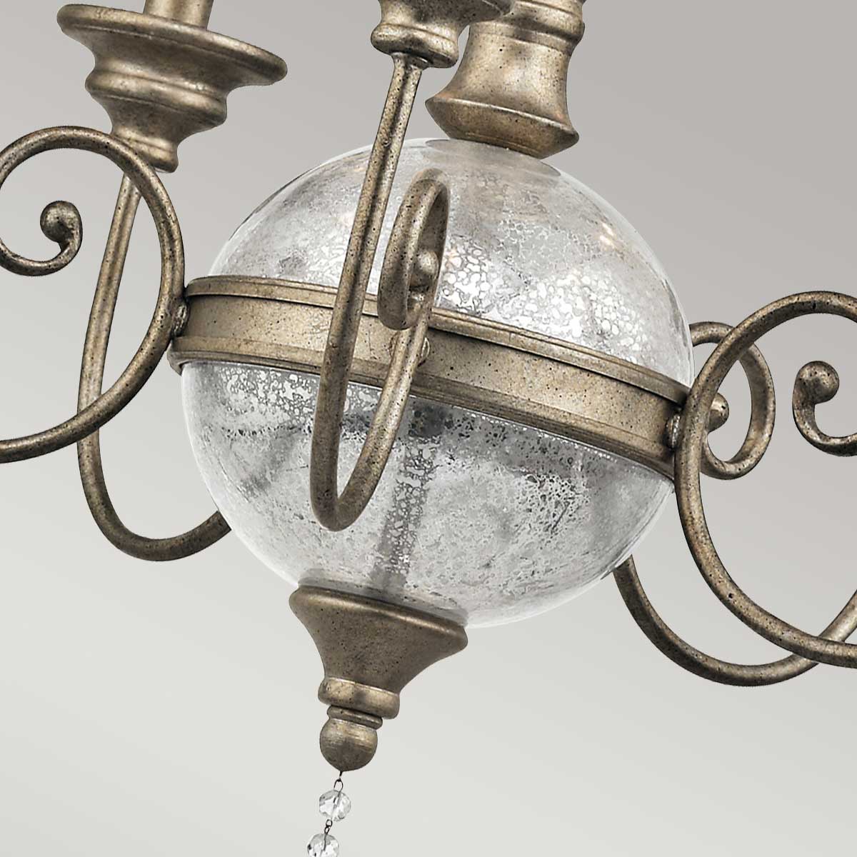 Gros plan sur la sphère de verre moucheté et son cerclage métallique doré antique
