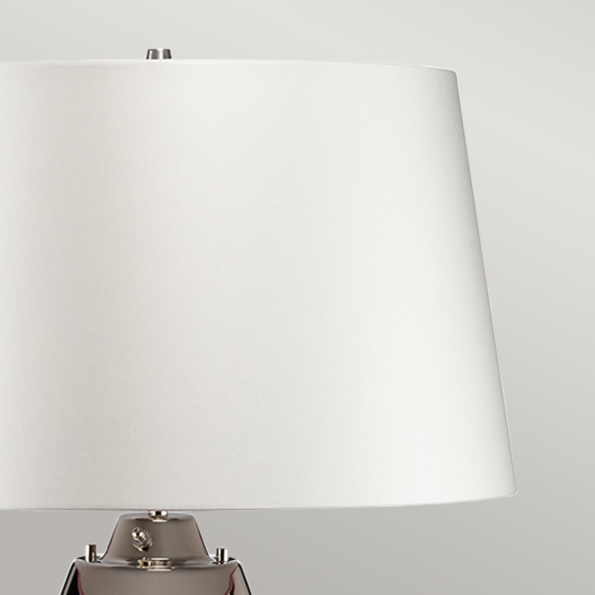 Gros plan sur l'abat-jour blanc et la fixation métallique au sommet du luminaire