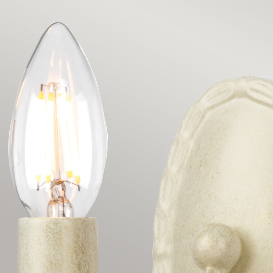 Détail de l'ampoule transparente allumée et de la douille crème