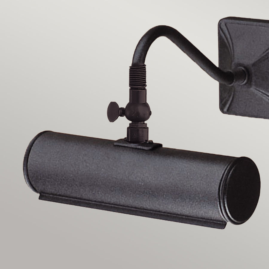 Gros plan sur l'articulation moletée et l'abat-jour cylindrique noir.