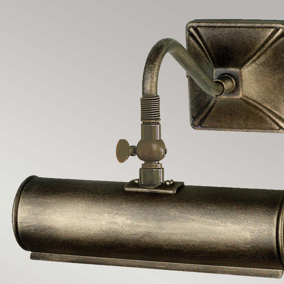 Détail du joint articulé et de la molette de réglage, près de l'abat-jour cylindrique.