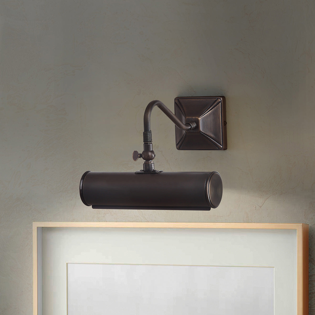 Mise en ambiance : applique fixée au mur au-dessus d'un cadre en bois clair
