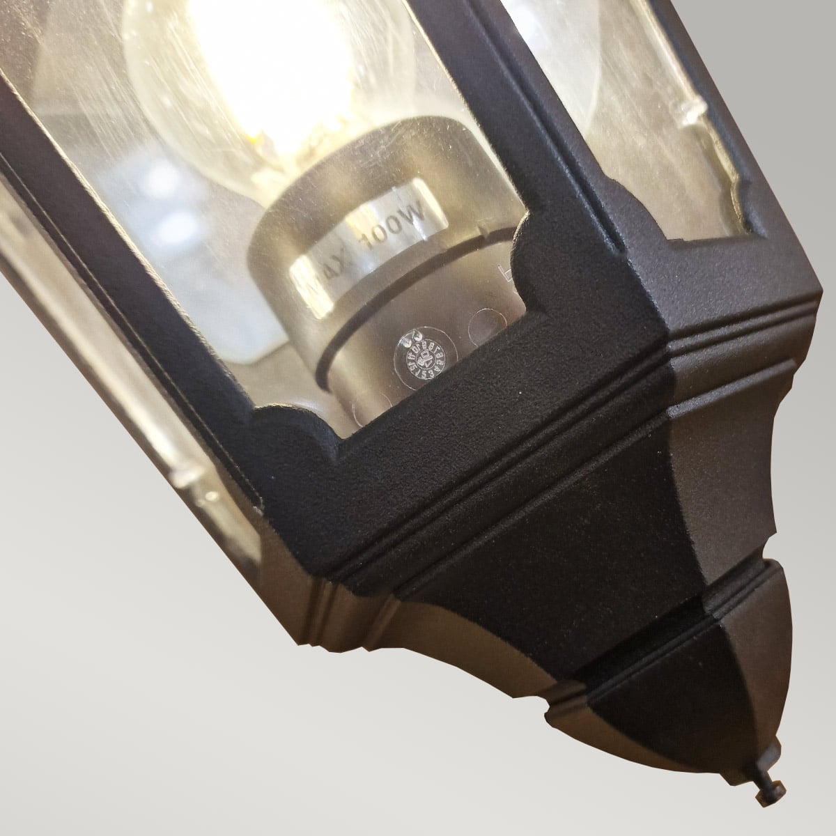 Gros plan sur la douille et l'ampoule, avec marquage 100W visible à travers le verre.