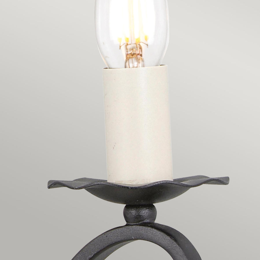 Gros plan sur une douille blanche, ampoule transparente et coupelle noire festonnée
