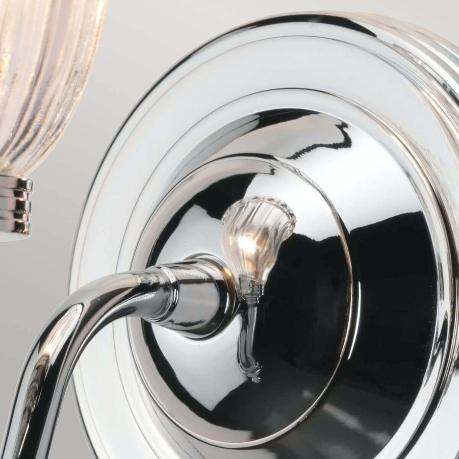 Détail du plateau mural rond et du bras courbe en chrome poli très réfléchissant
