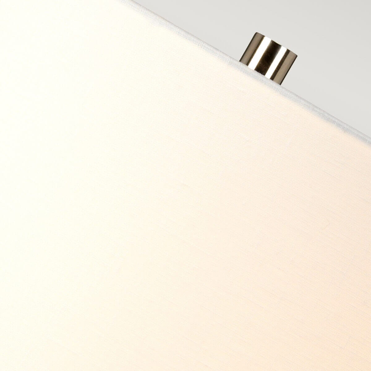 Détail du sommet de l'abat-jour blanc et fixation métallique cylindrique.
