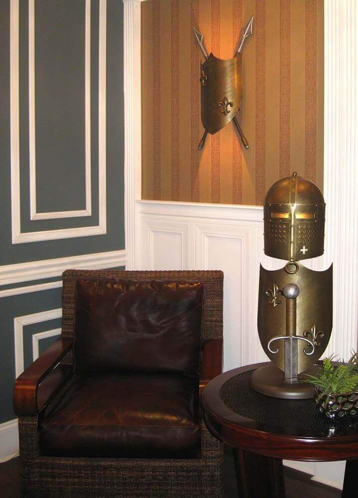 Mise en ambiance salon avec fauteuil, lampe posée sur table ronde en bois.