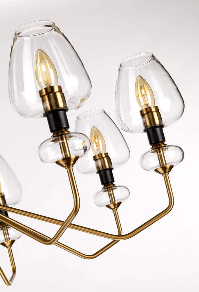 Gros plan sur trois lumières allumées, verre clair, douilles noires et bras en laiton.