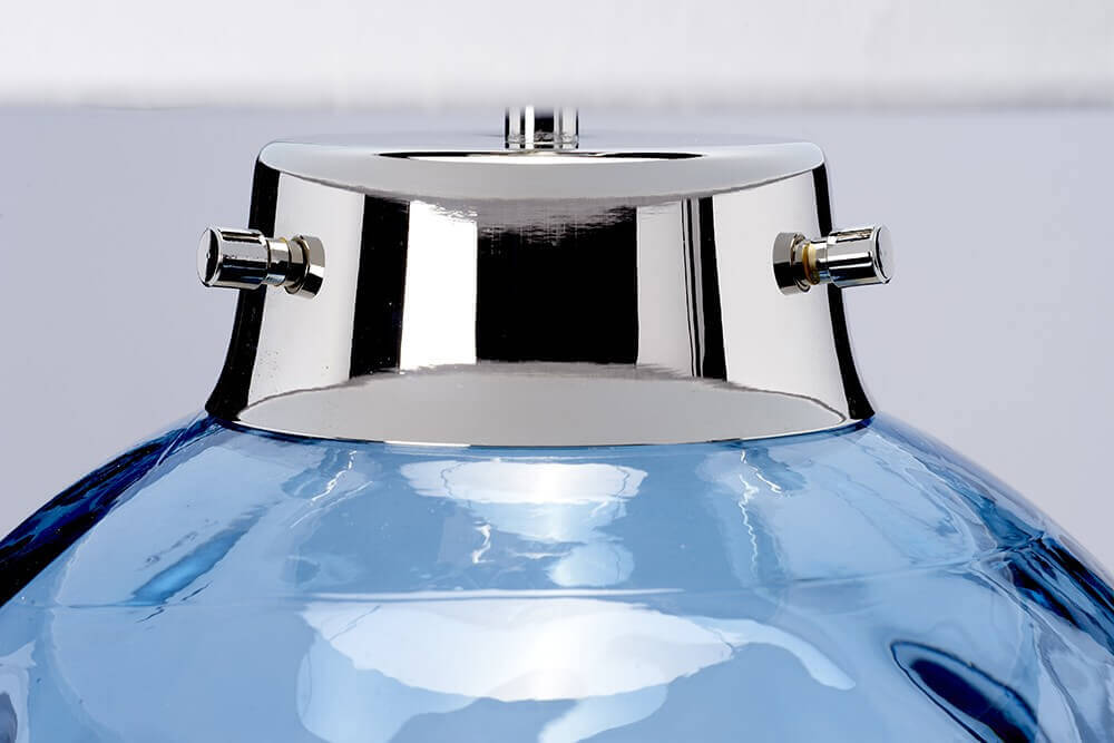 Détail du collier en métal nickel poli et vis apparentes sur verre bleu