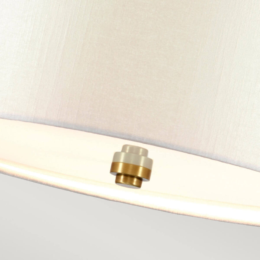 Détail du cabochon central en laiton sous l'abat-jour crème de la suspension