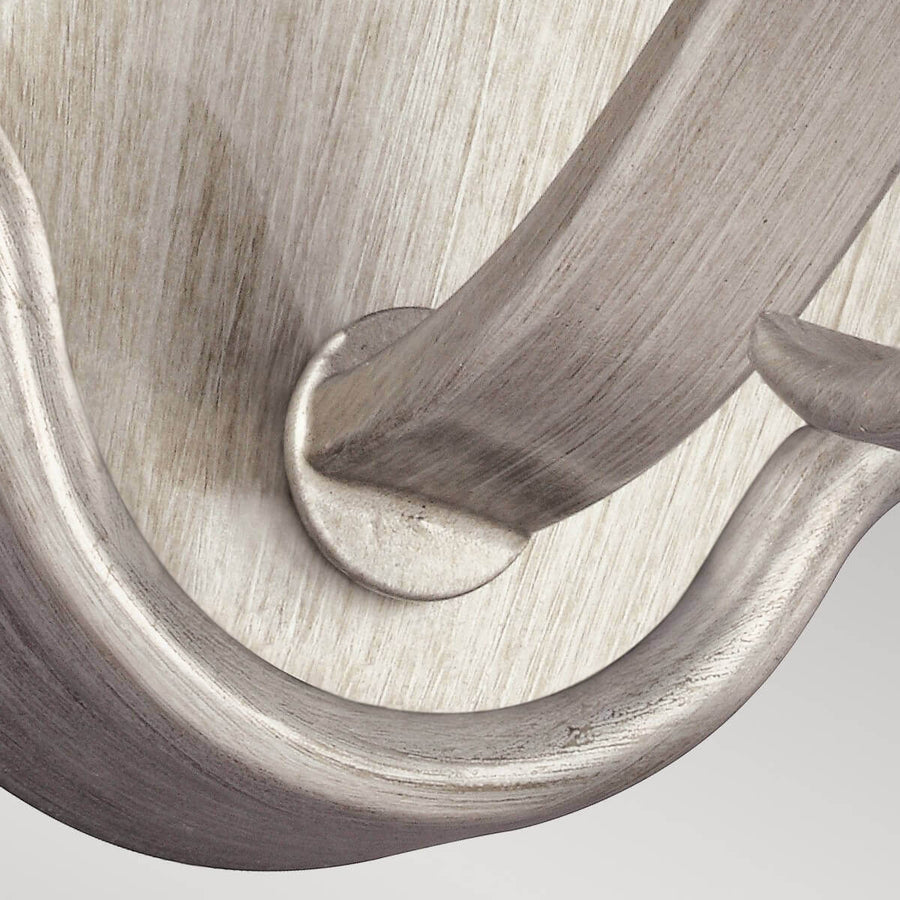 Détail du bras courbé fixé à la platine par une vis
