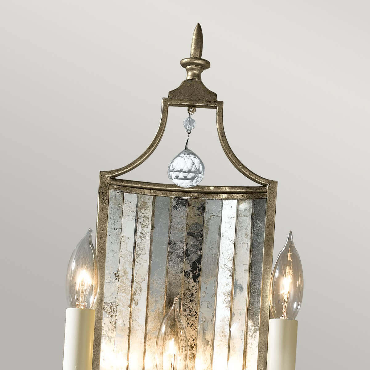 Détail du sommet : pointe métallique dorée, goutte de cristal et panneau miroir festonné