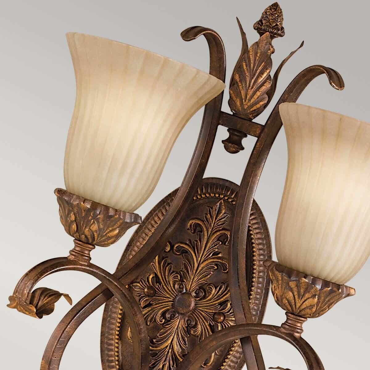 Vue rapprochée des deux diffuseurs en verre strié et du fleuron central sculpté.