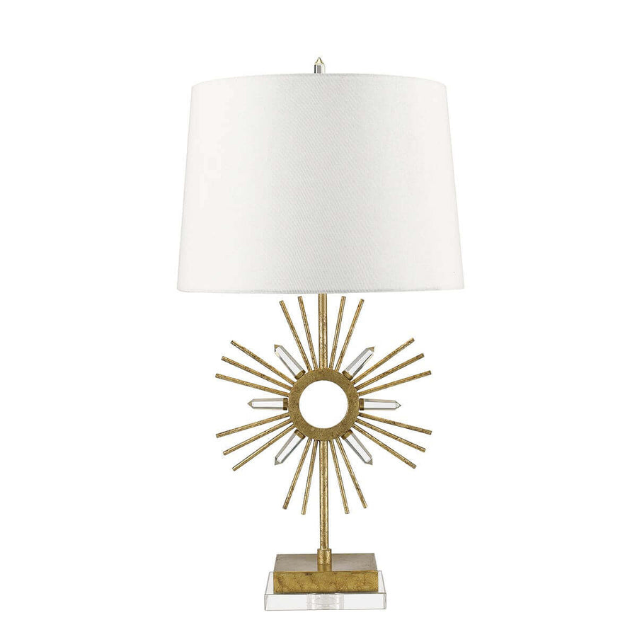 Lampe à poser dorée avec abat-jour blanc, motif soleil et base carrée en verre.