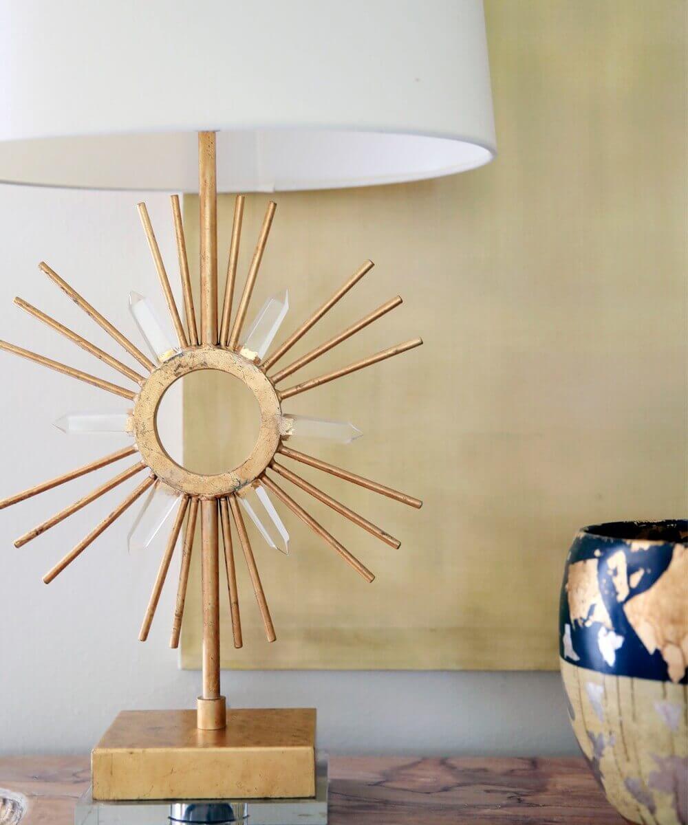 Détail du motif soleil doré et des cristaux transparents sur fond jaune.