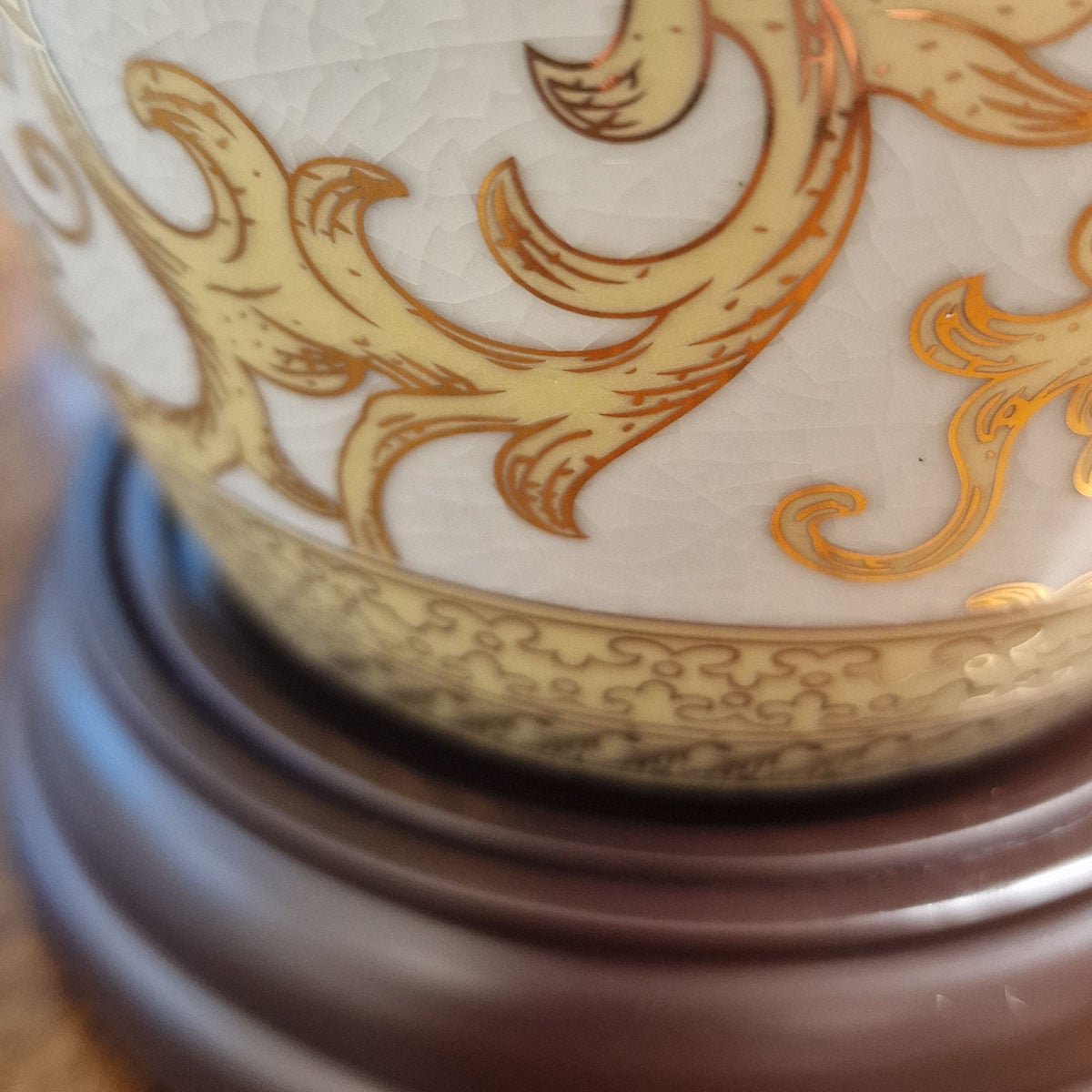 Gros plan sur la base en bois sombre et le pied de la porcelaine