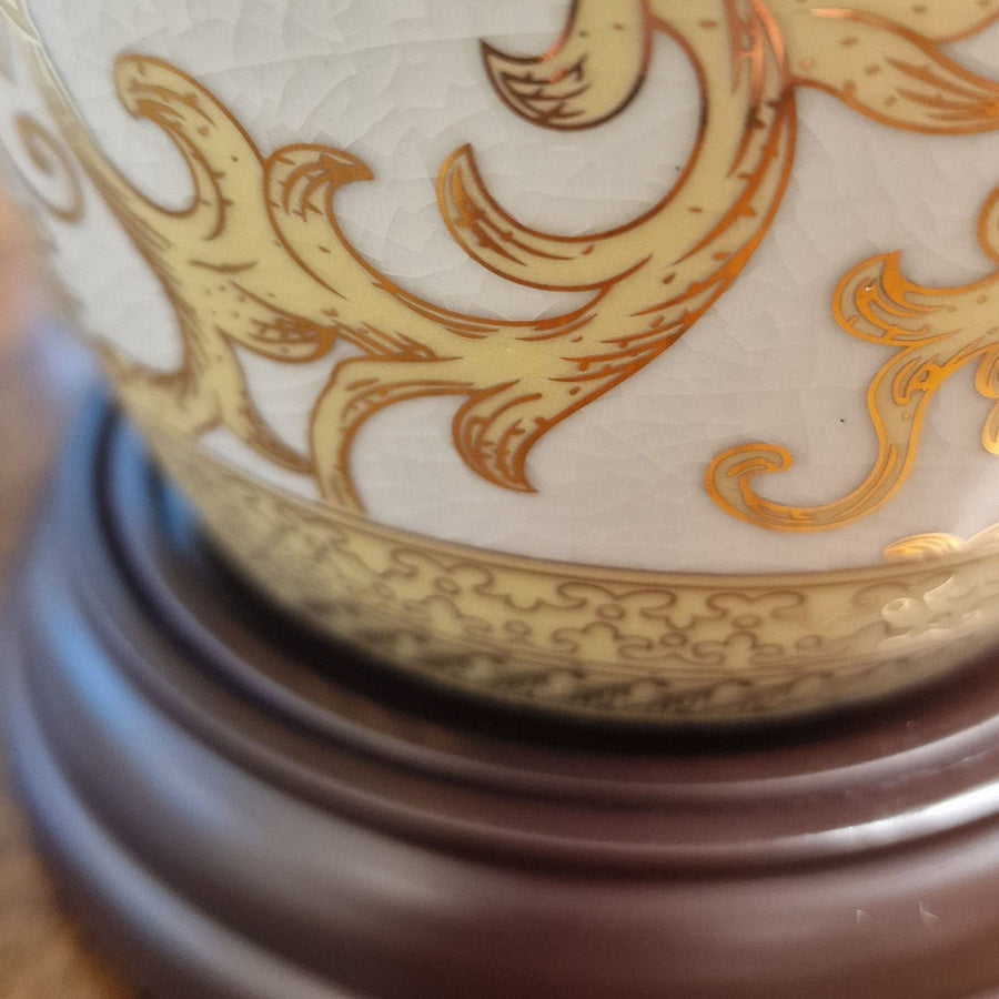 Gros plan sur la base en bois sombre et le pied de la porcelaine