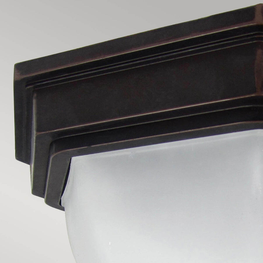 Détail de la finition bronze et du bord mouluré maintenant le verre dépoli