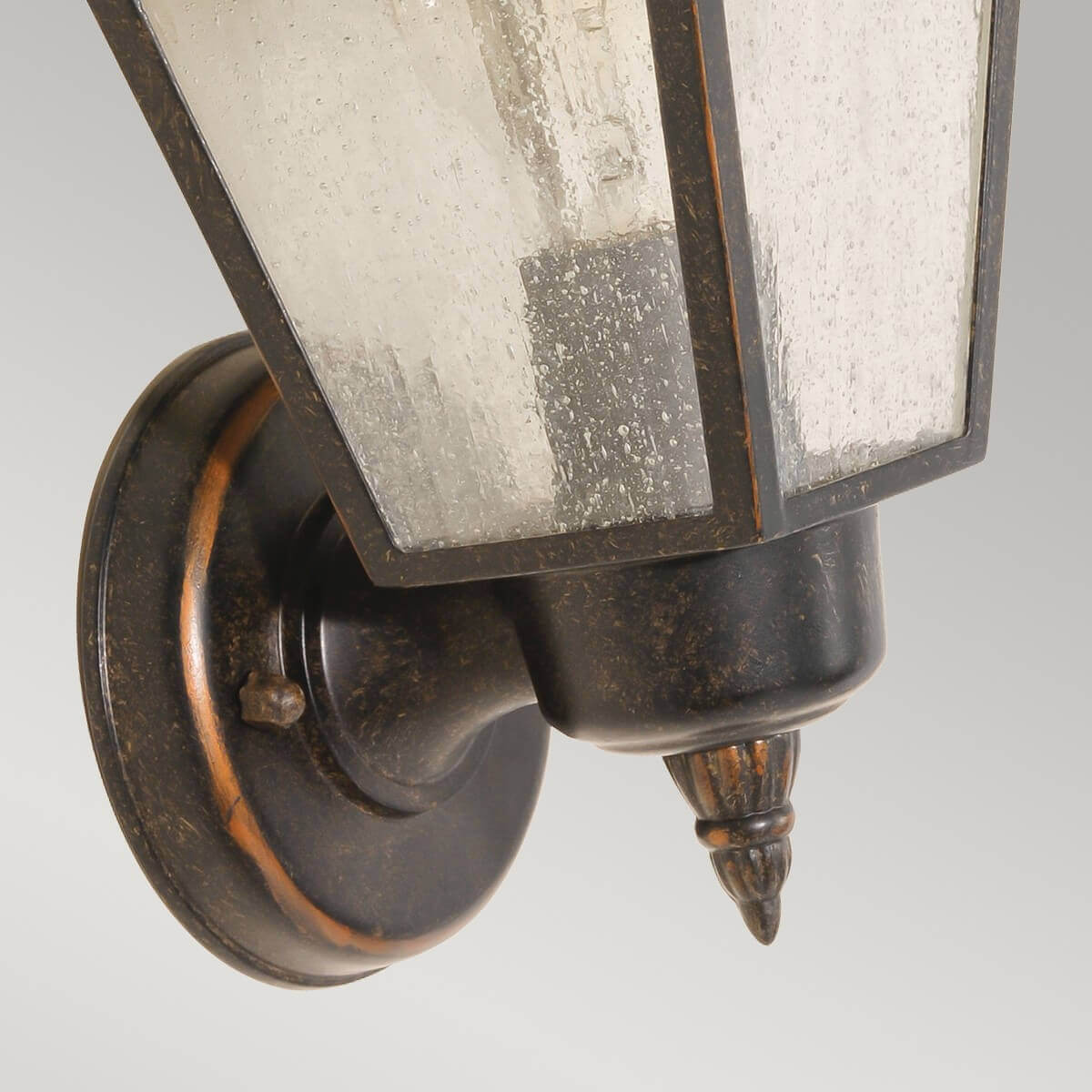 Détail de la platine ronde et du bras de fixation contre le mur