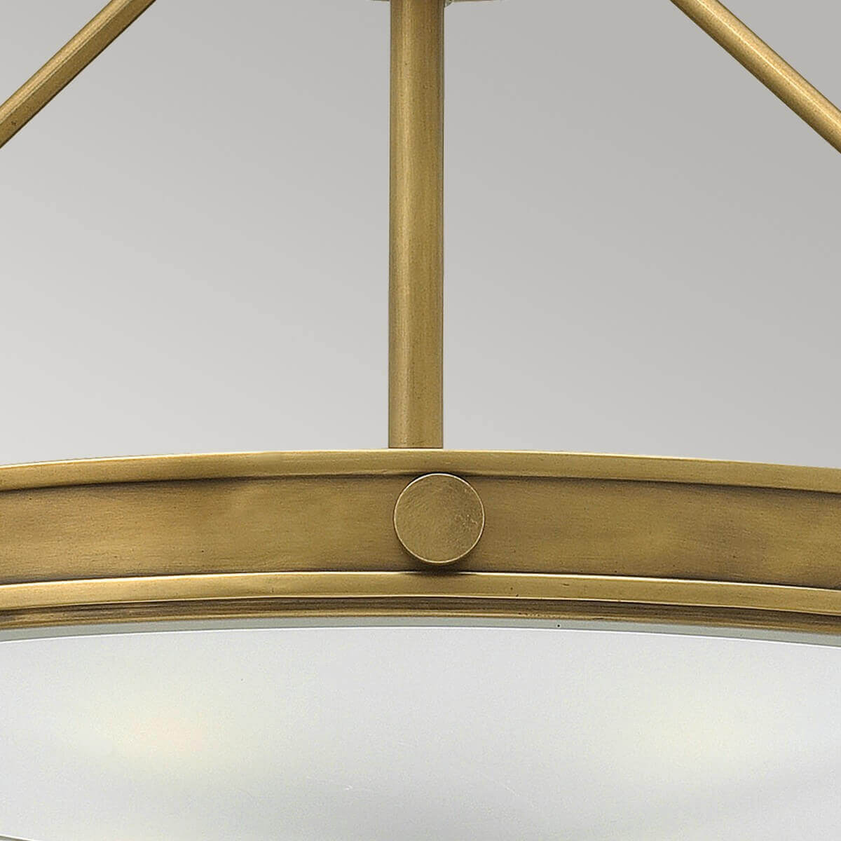 Détail de la tige centrale et du cercle en laiton avec pastille circulaire décorative.