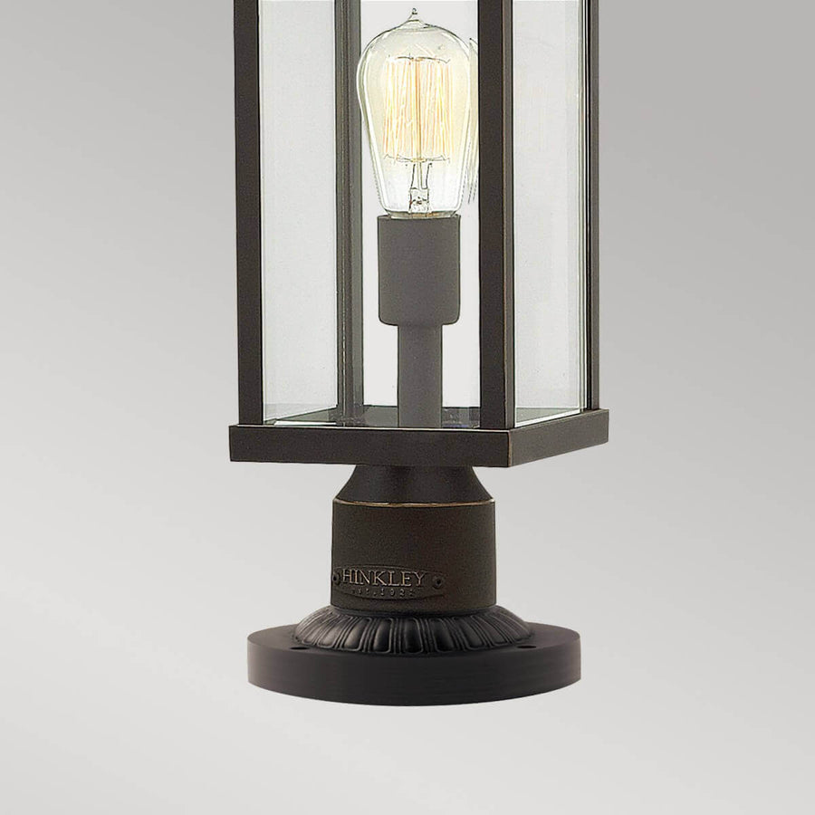 Gros plan sur l'ampoule Edison et la base ronde gravée du luminaire