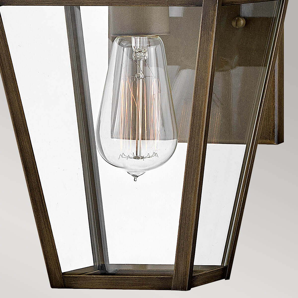 Gros plan de l'ampoule à filament visible derrière le verre clair