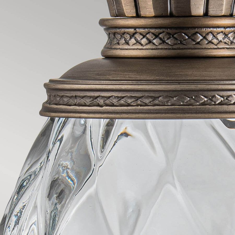 Gros plan du collet mouluré orné reliant la couronne de feuilles au verre