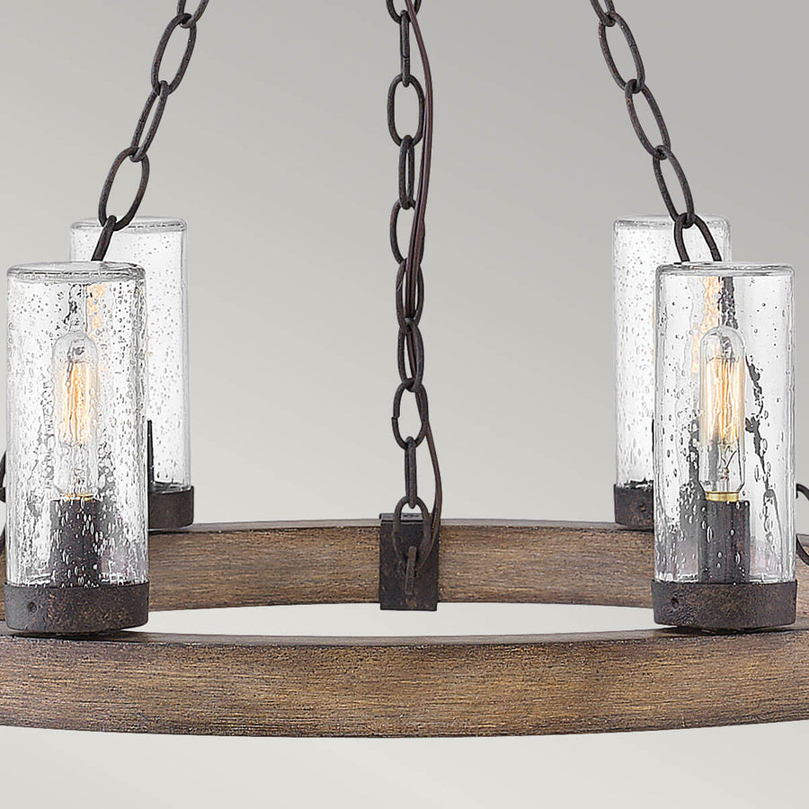 Vue rapprochée de l'anneau en bois et des lanternes cylindriques en verre.