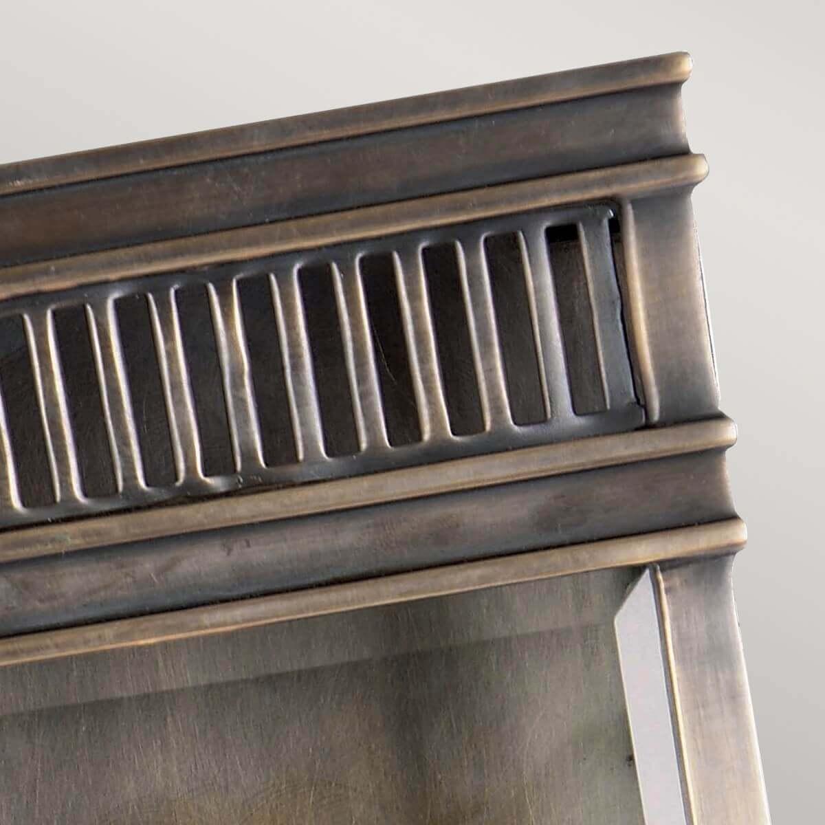 Détail du haut de l'applique montrant la grille ajourée en bronze brossé