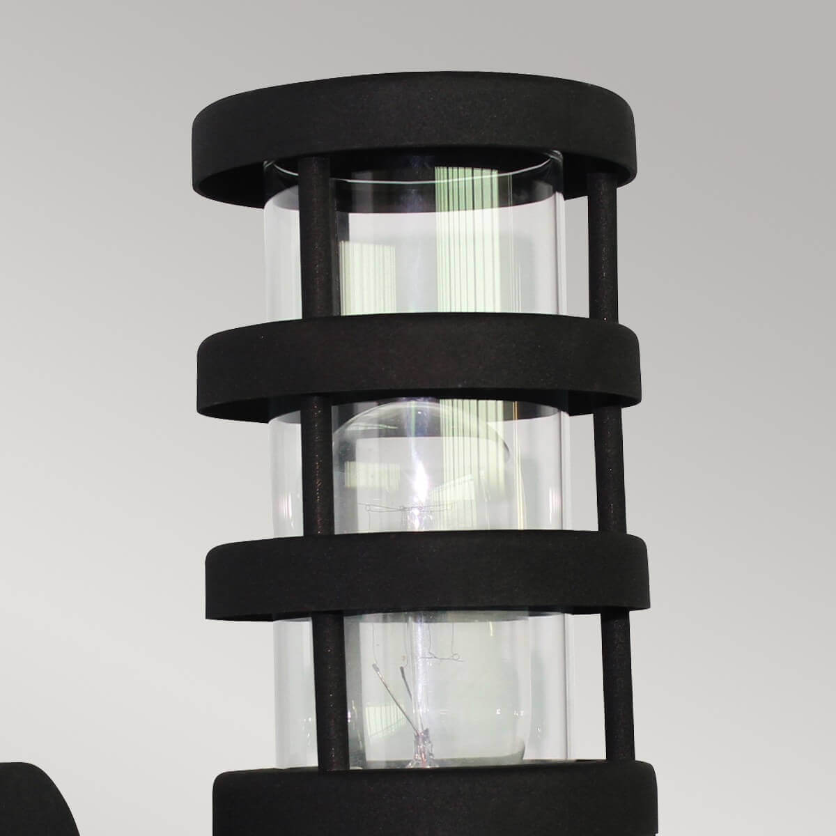 Gros plan sur la cage, le verre transparent et l'ampoule à l'intérieur du luminaire.