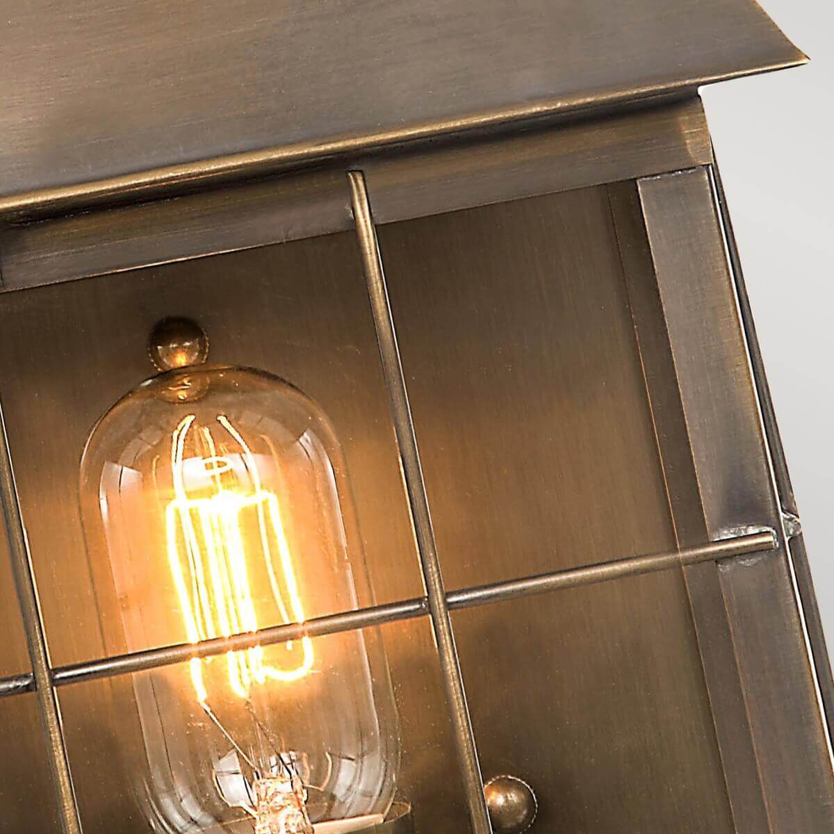 Gros plan sur la grille métallique et l'ampoule à filament derrière le verre
