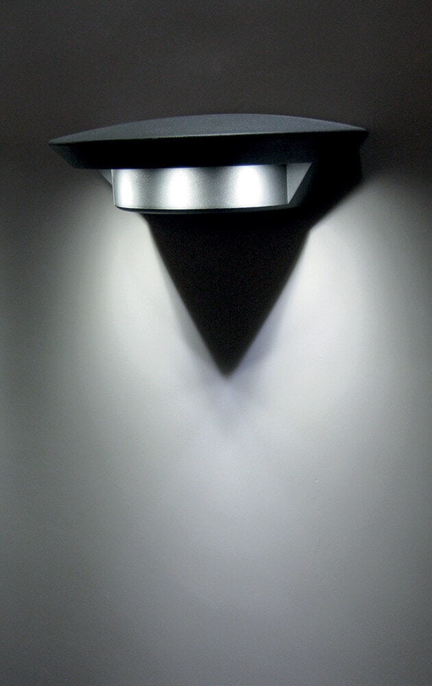 Mise en ambiance nocturne : faisceau lumineux triangulaire projeté sur un mur sombre