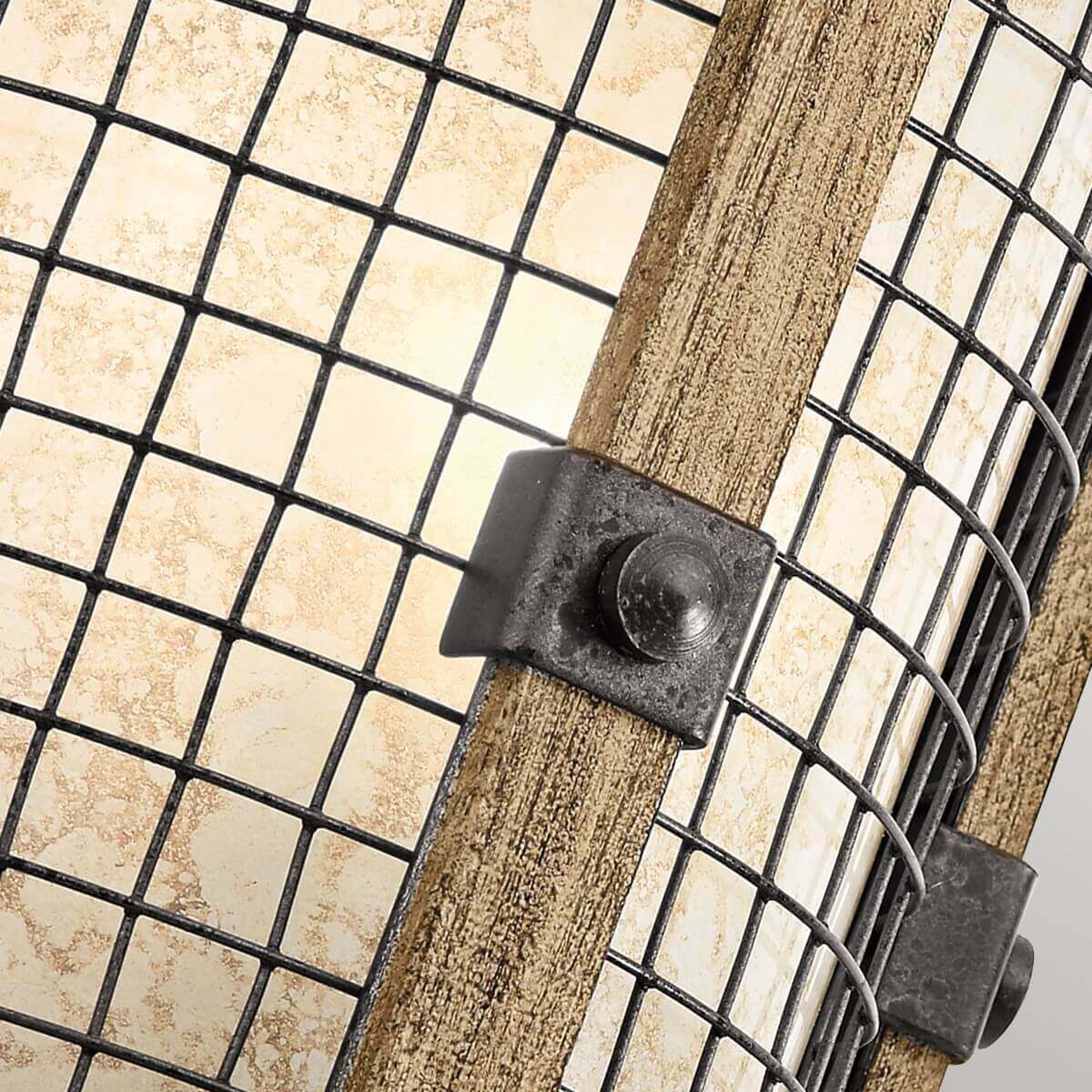 Gros plan sur la grille métallique, la latte en bois et le collier de serrage boulonné.