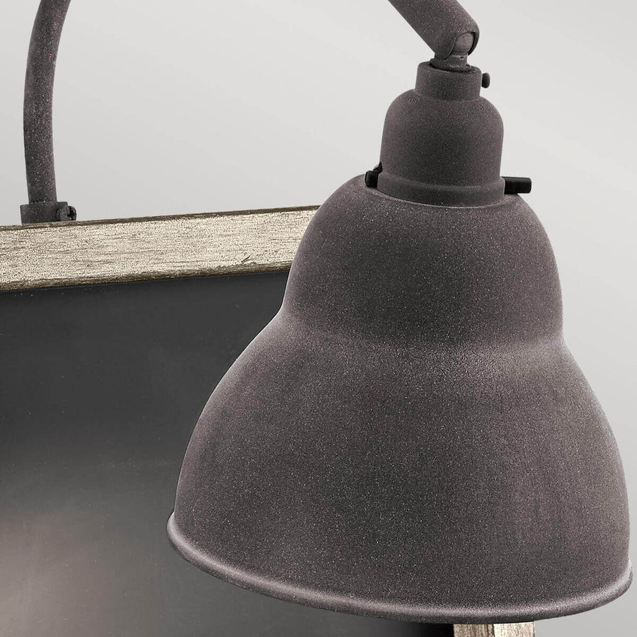 Gros plan sur la tête de lampe métallique texturée et son bras articulé.