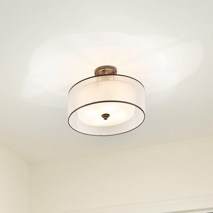 Luminaire allumé fixé au plafond blanc, halo lumineux diffus tout autour