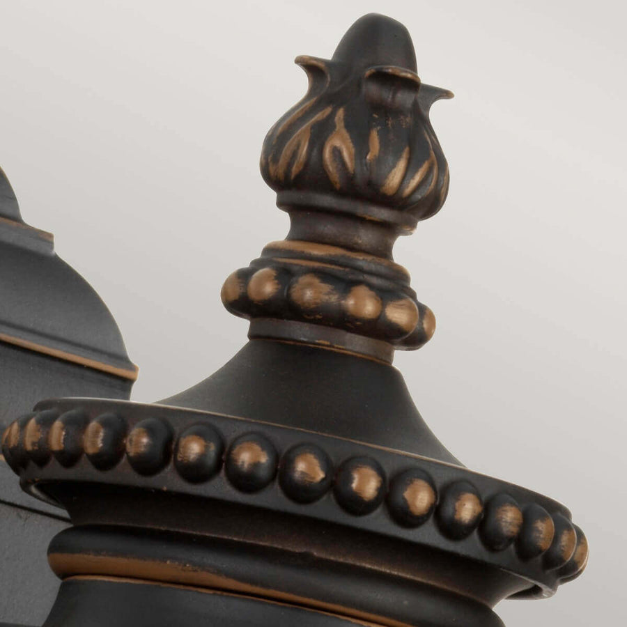 Détail du sommet mouluré et de la bille ornée de l'applique bronze