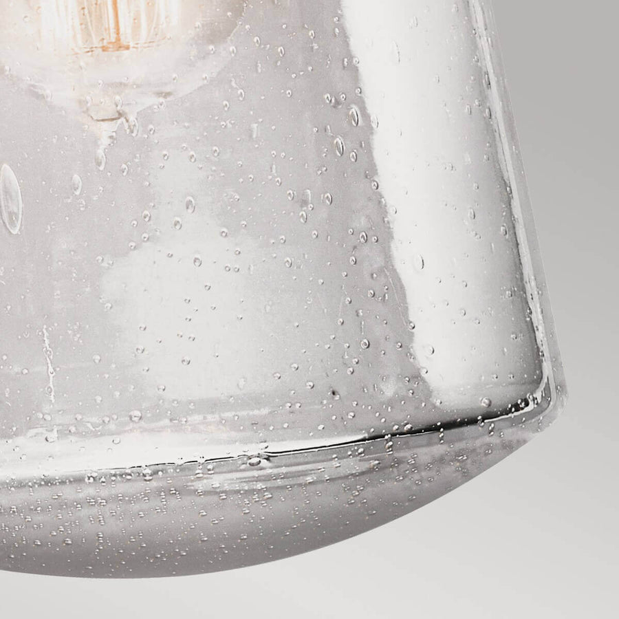 Détail rapproché du verre bullé et de l'ampoule à filament allumée