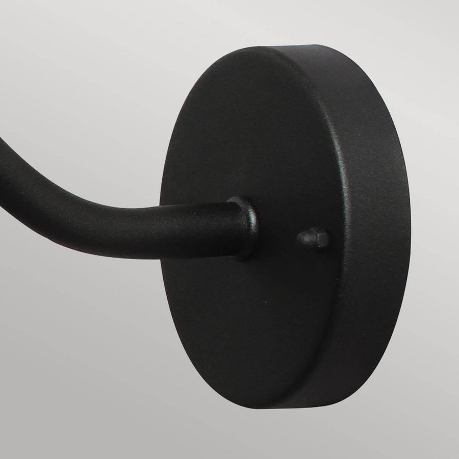 Détail de la platine murale ronde noire fixée par une vis apparente
