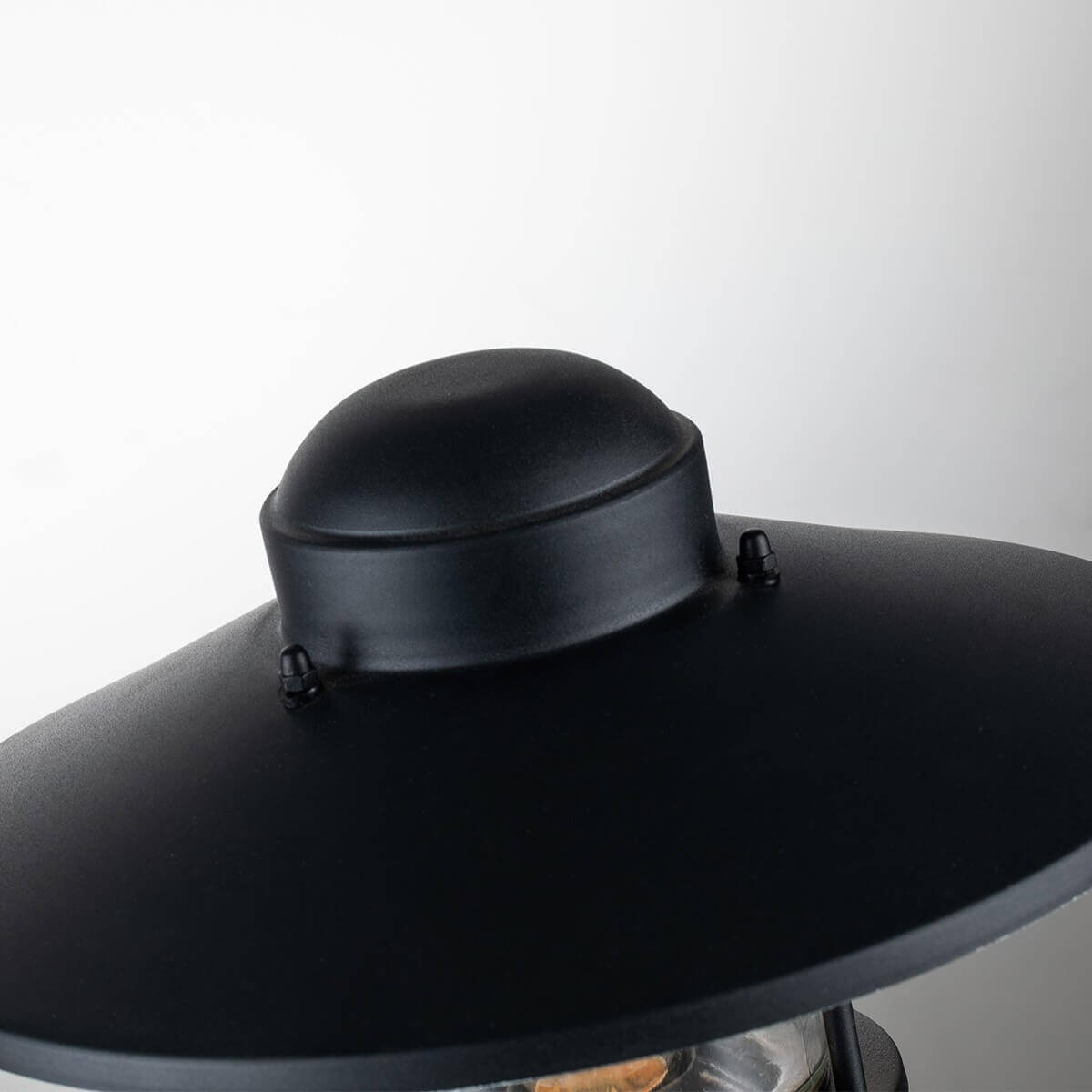 Gros plan du dôme supérieur noir et des vis de fixation du chapeau