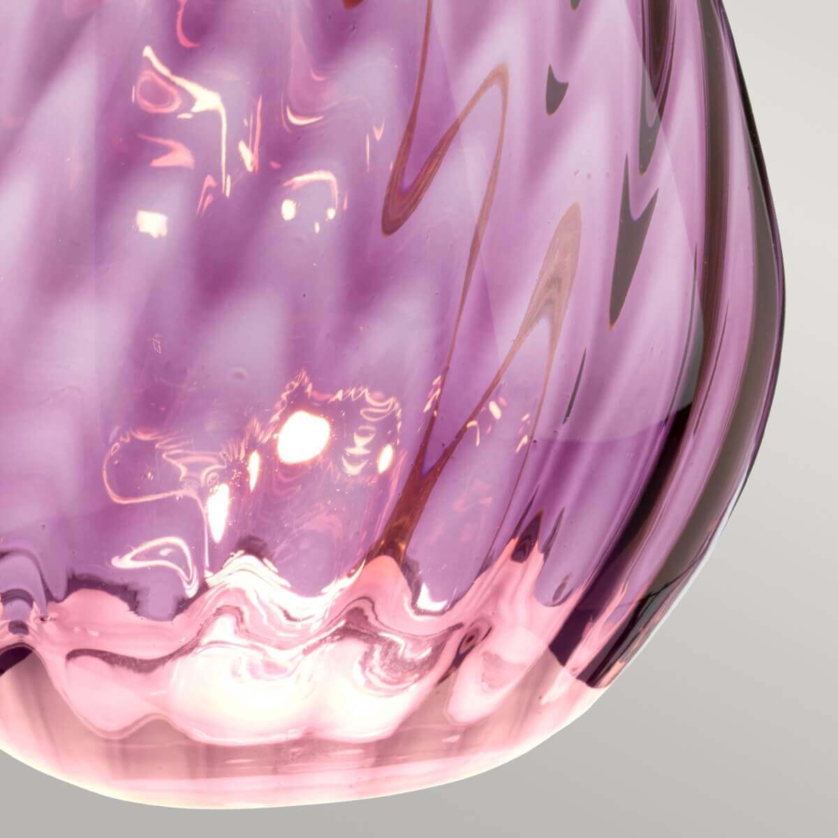 Gros plan sur le verre violet moucheté et ses reflets lumineux